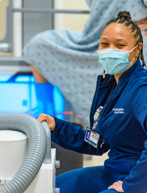 A smiling x-ray technician taking an x-ray of a patient’s foot 
