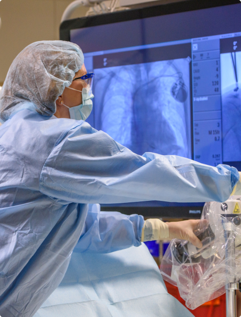 Cardiovascular professional looking at heart images on a computer monitor in an operating room 